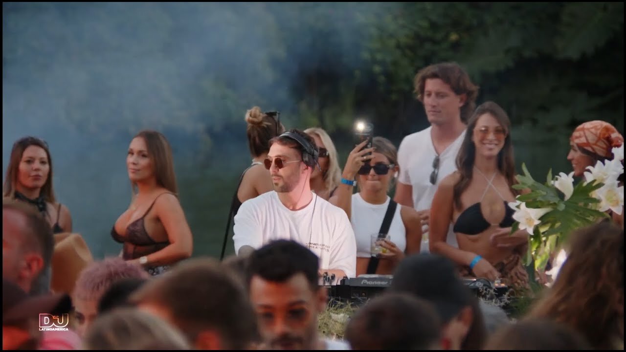 Hot Since 82 in the DJ booth surrounded by the crowd by a lagoon